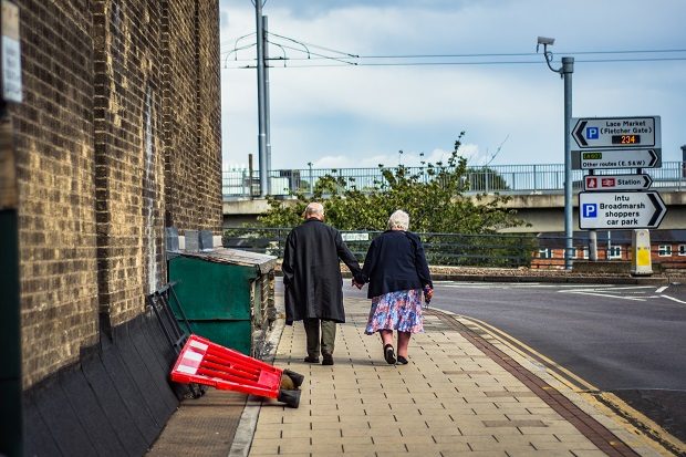 An older couple holding hands.