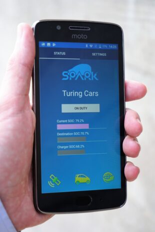 Hand holding smart phone with the Spark EV app.