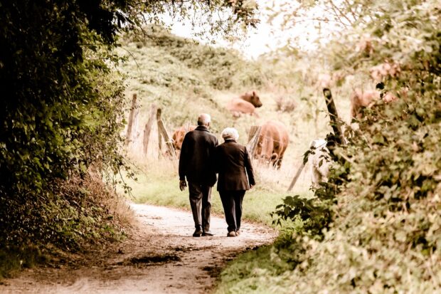 Older couple walking down a country path.