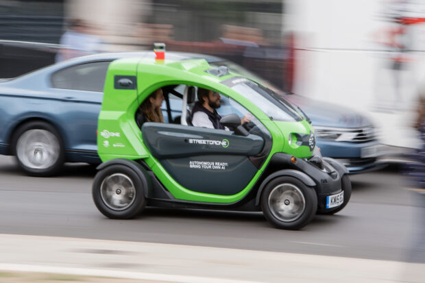 Small electric car speeding down a street.