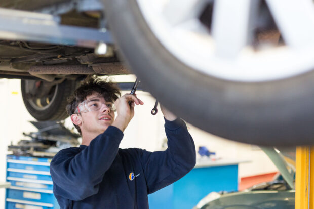 Student learning car maintenance