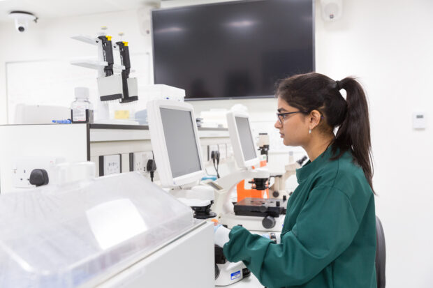 Student in the lab examining breast cancer cells