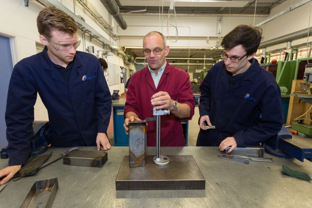 Students and teacher demonstrating engineering techniques