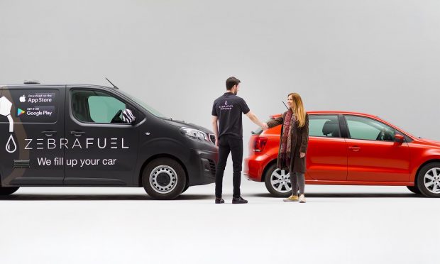 Zebra Fuel van next to a small car with 2 people in front.