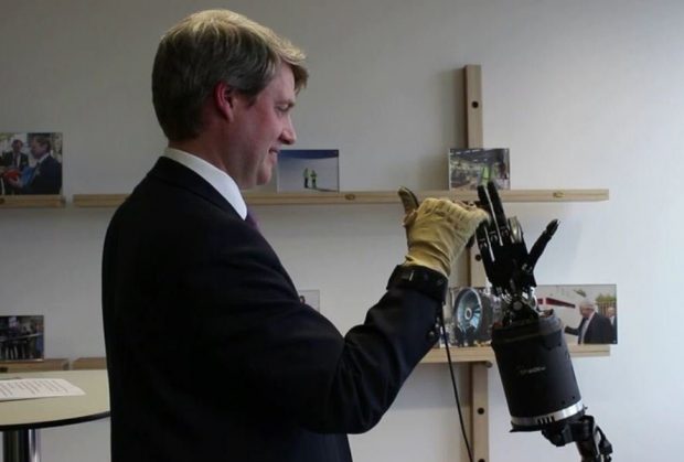 Chris Skidmore with a robotic arm.